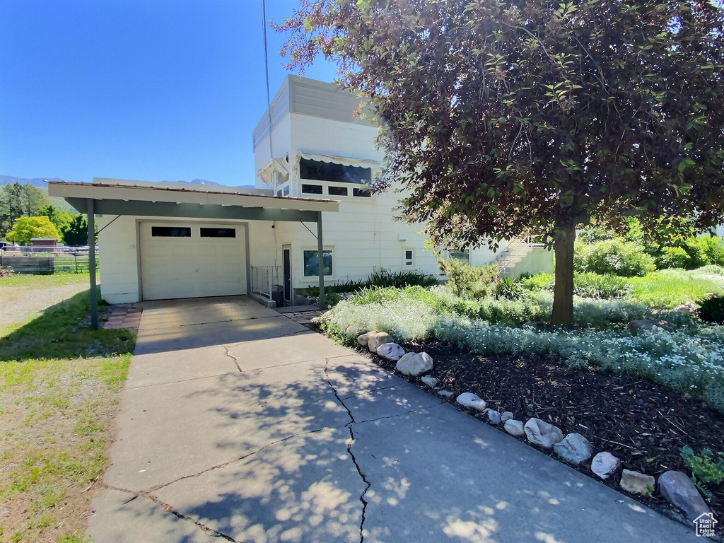 View of front of property featuring concrete driveway and a garage