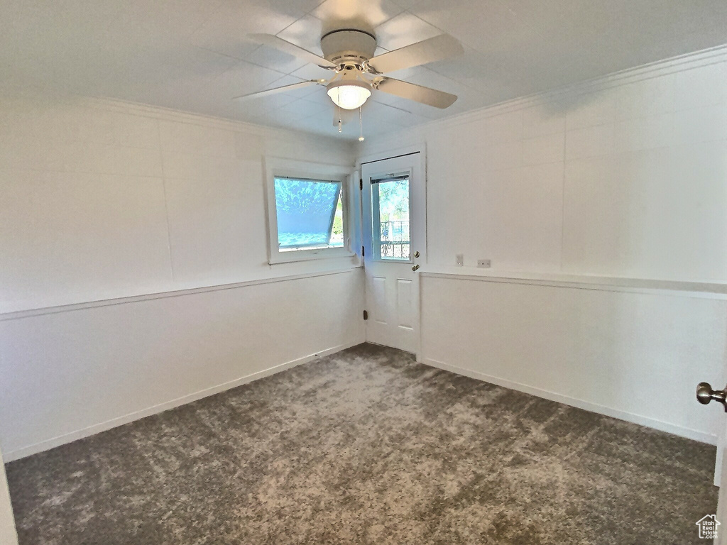 Carpeted empty room with crown molding, ceiling fan, and baseboards