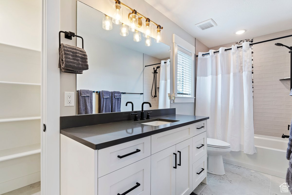Full bathroom with vanity, shower / tub combo with curtain, and toilet