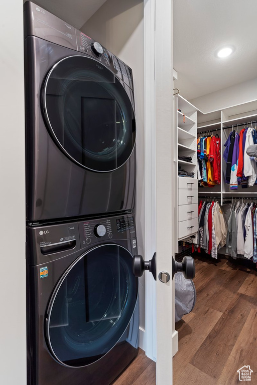 Washroom featuring stacked washer and clothes dryer and wood finished floors
