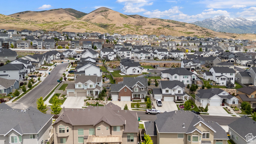 Aerial view of property and surrounding area with nearby suburban area and a mountainous background