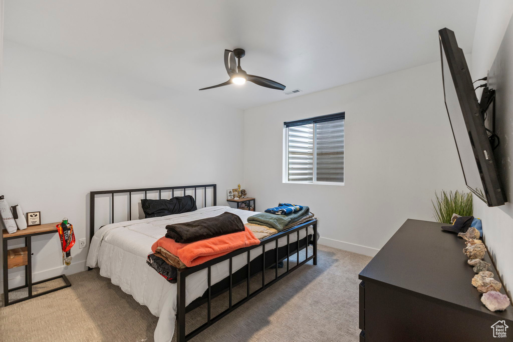 Carpeted bedroom featuring baseboards and a ceiling fan