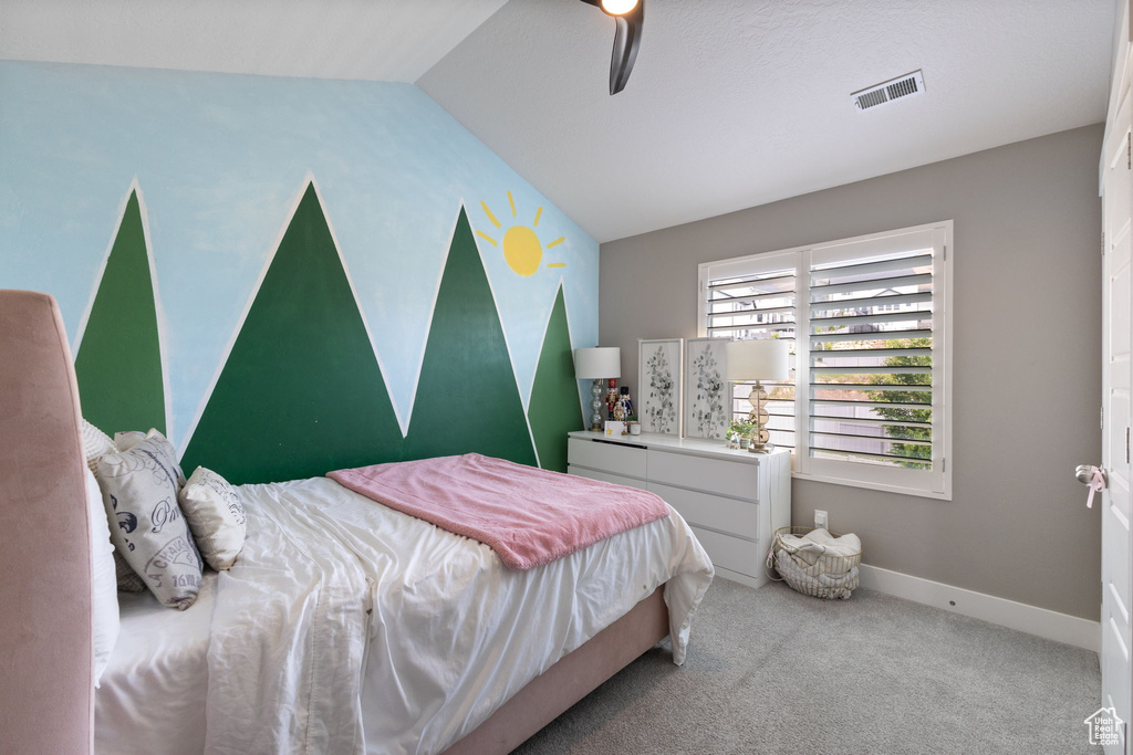 Carpeted bedroom featuring vaulted ceiling, ceiling fan, and baseboards