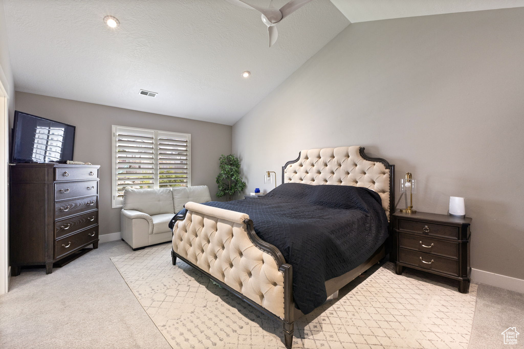 Bedroom with lofted ceiling, light carpet, and baseboards