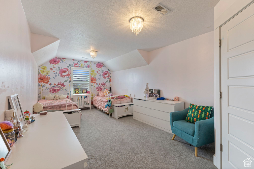 Bedroom with carpet flooring, a textured ceiling, lofted ceiling, and wallpapered walls