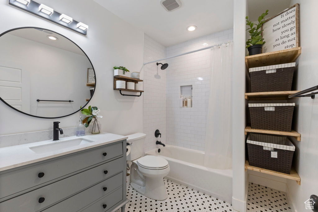 Bathroom with vanity, toilet, and shower / bath combo with shower curtain