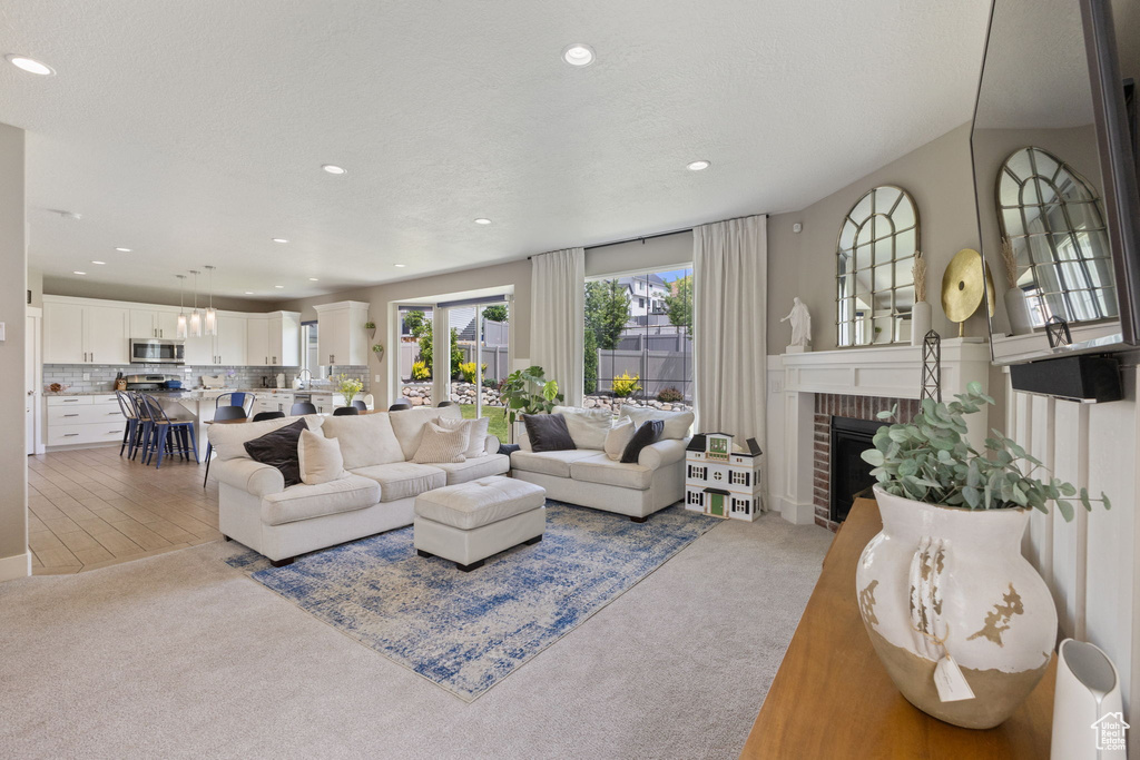 Carpeted living room with recessed lighting and a fireplace