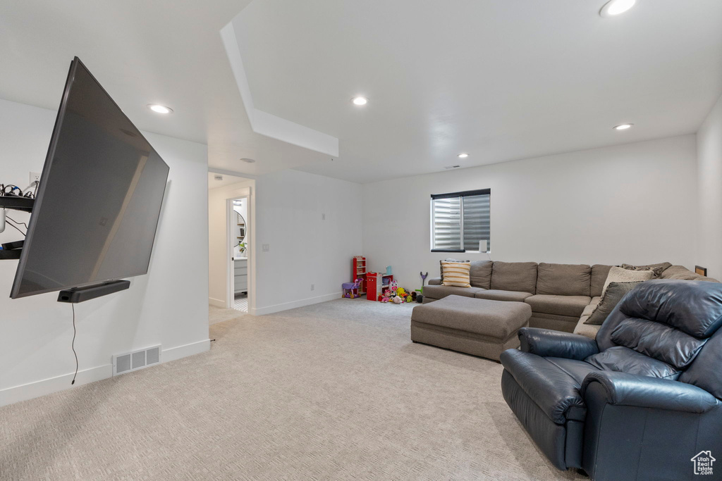 Living room with recessed lighting, light colored carpet, and baseboards