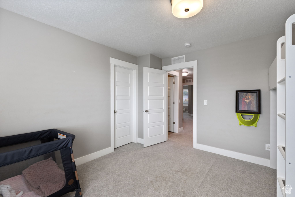 Carpeted office space featuring baseboards and a textured ceiling