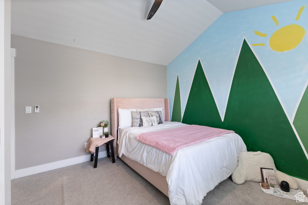 Carpeted bedroom with ceiling fan and lofted ceiling
