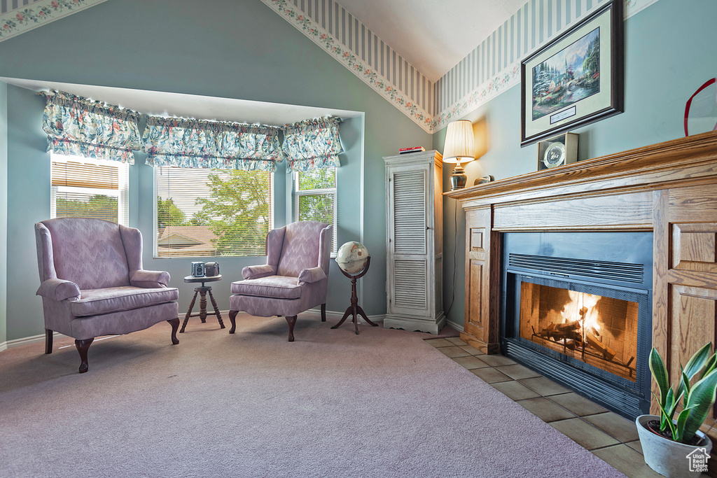 Sitting room with a tile fireplace, high vaulted ceiling, carpet floors, and baseboards
