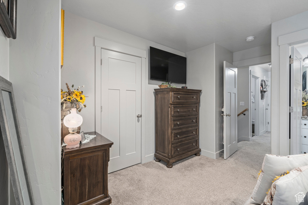 Bedroom with light colored carpet and baseboards