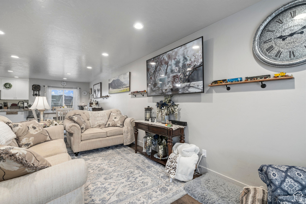 Living room featuring baseboards, recessed lighting, and wood finished floors