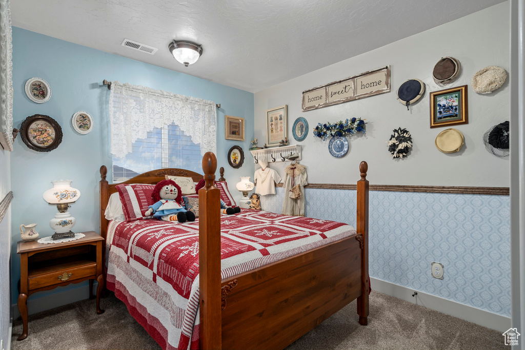 Carpeted bedroom featuring wainscoting and wallpapered walls