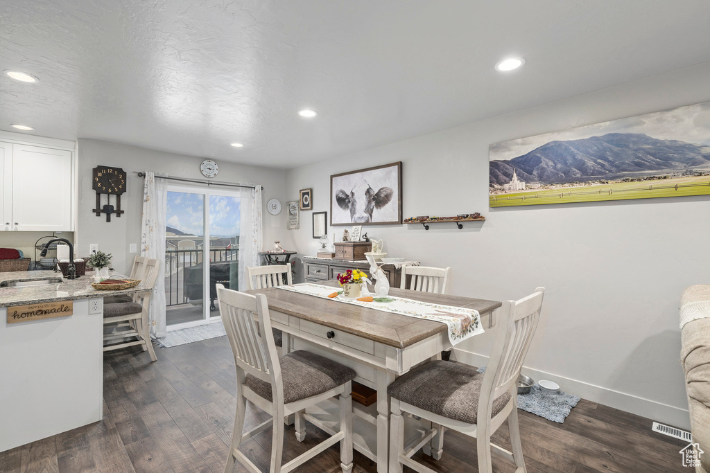 Dining area with dark wood finished floors, recessed lighting, and baseboards