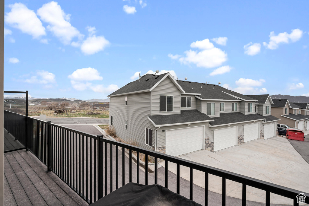 Wooden deck with a residential view, driveway, and a garage