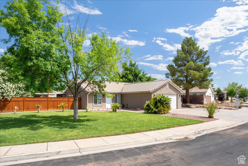 Ranch-style house with a garage, stucco siding, concrete driveway, and a tile roof