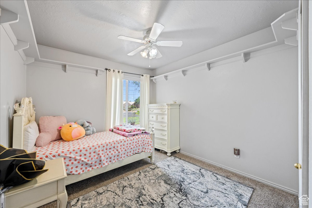 Bedroom with carpet floors, baseboards, a textured ceiling, and ceiling fan