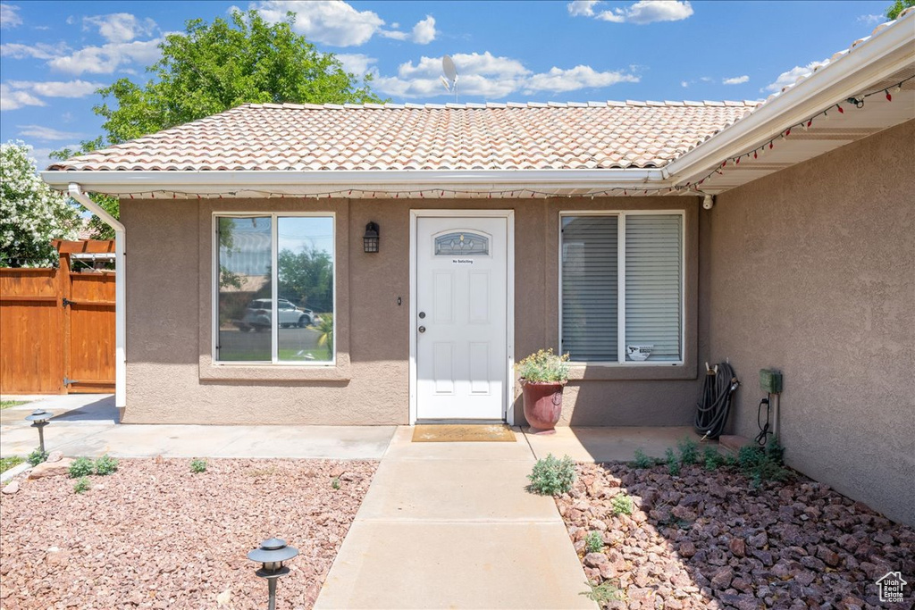 Doorway to property with stucco siding and a tile roof