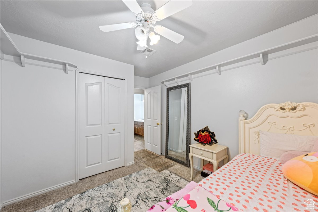 Carpeted bedroom with baseboards, a closet, and ceiling fan
