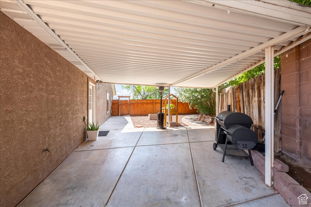 Fenced backyard featuring a patio area and a grill