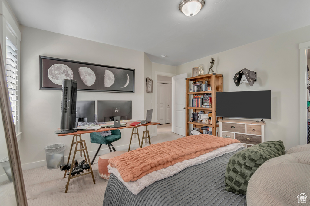 Bedroom with carpet, an office area, and baseboards