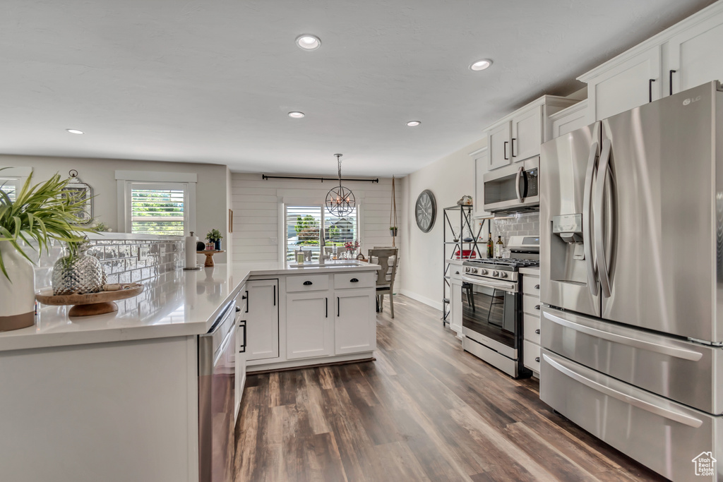 Kitchen featuring stainless steel appliances, recessed lighting, white cabinetry, backsplash, and dark wood-style floors