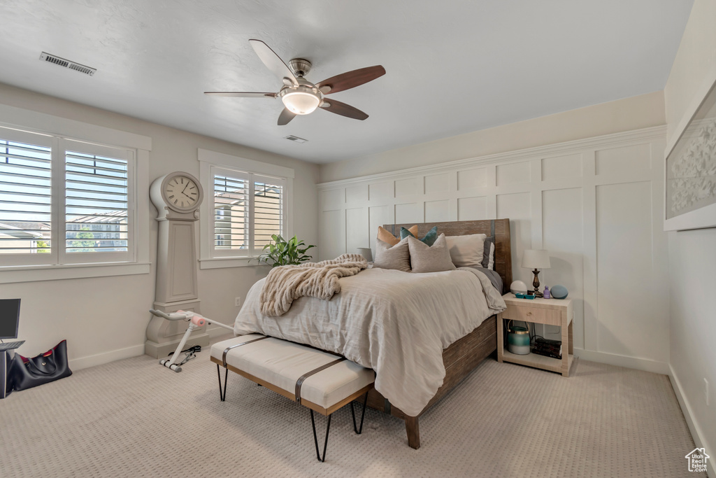 Bedroom with baseboards, light carpet, and ceiling fan