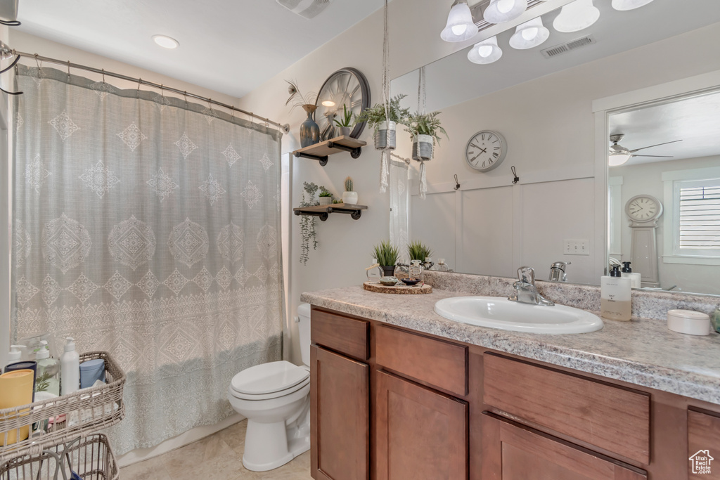 Full bathroom featuring vanity, a ceiling fan, toilet, shower / bathtub combination with curtain, and tile patterned flooring