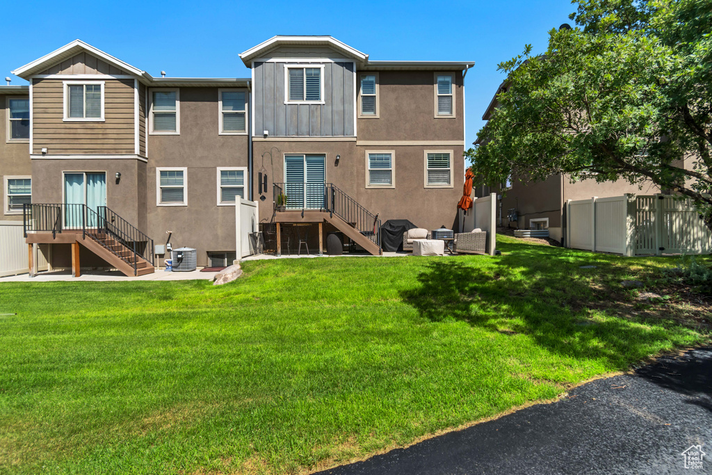 Back of house featuring stairway, central air condition unit, stucco siding, and board and batten siding