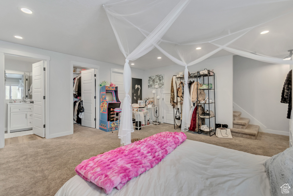 Carpeted bedroom with recessed lighting, baseboards, vaulted ceiling, ensuite bathroom, and a spacious closet
