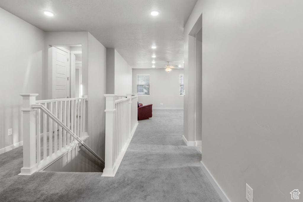 Corridor featuring an upstairs landing, carpet flooring, baseboards, and recessed lighting