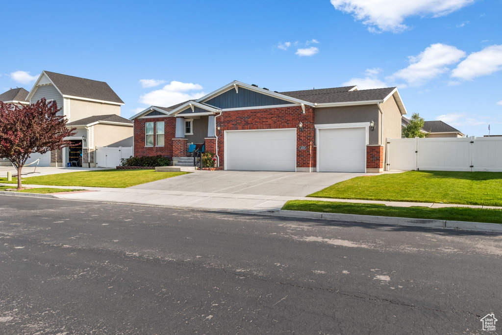 Craftsman-style home with a gate, an attached garage, brick siding, and concrete driveway