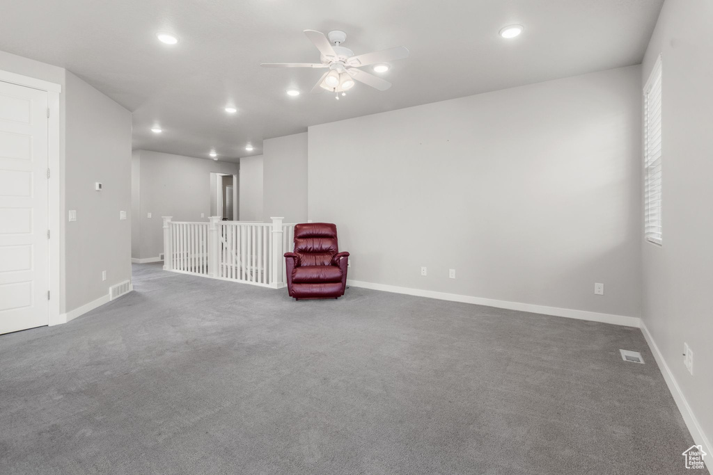 Unfurnished room featuring recessed lighting, a ceiling fan, carpet flooring, baseboards, and an upstairs landing