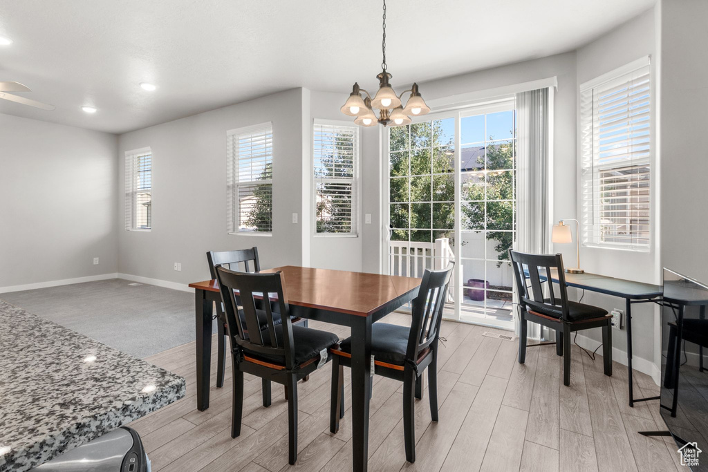 Dining area featuring baseboards, a chandelier, plenty of natural light, and recessed lighting