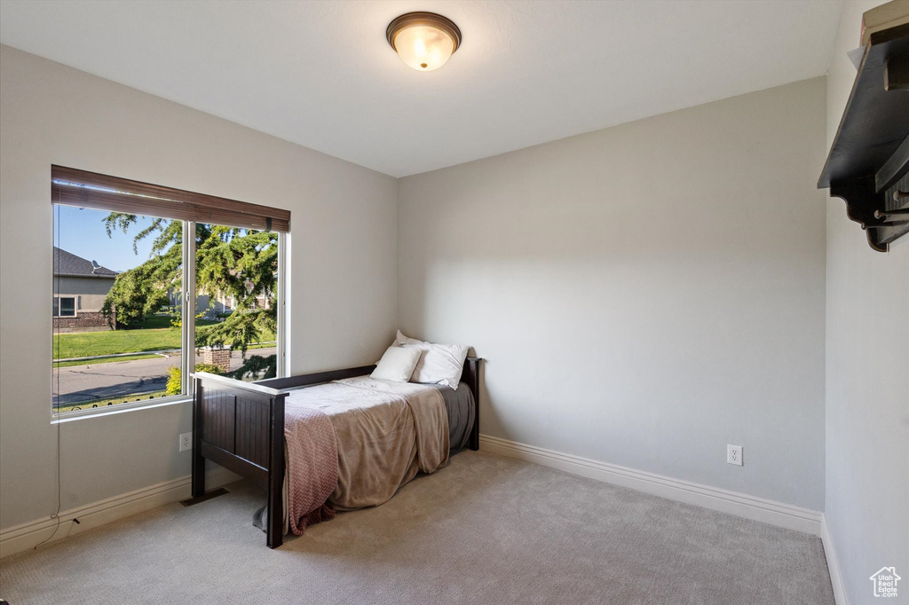 Bedroom featuring light colored carpet and baseboards