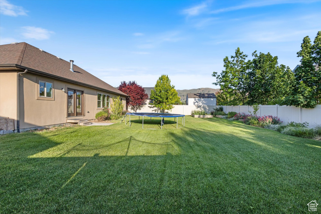 View of yard featuring a trampoline and entry steps