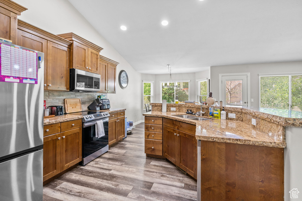 Kitchen featuring stainless steel appliances, a sink, wood finished floors, recessed lighting, and tasteful backsplash