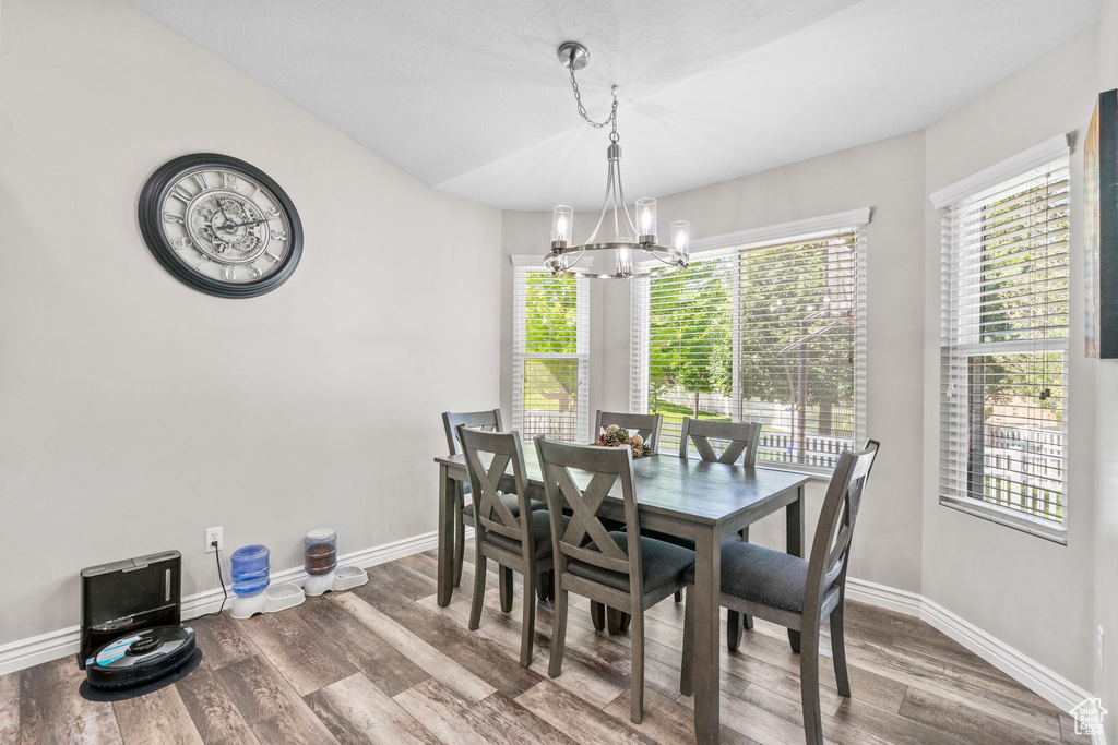 Dining room featuring a chandelier, wood finished floors, and baseboards