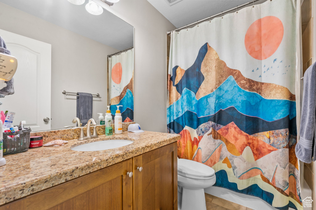 Bathroom featuring vanity, toilet, and a shower with curtain