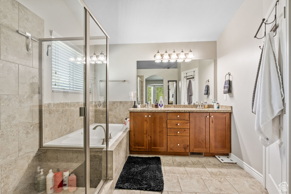 Bathroom with a bath, double vanity, and tiled shower