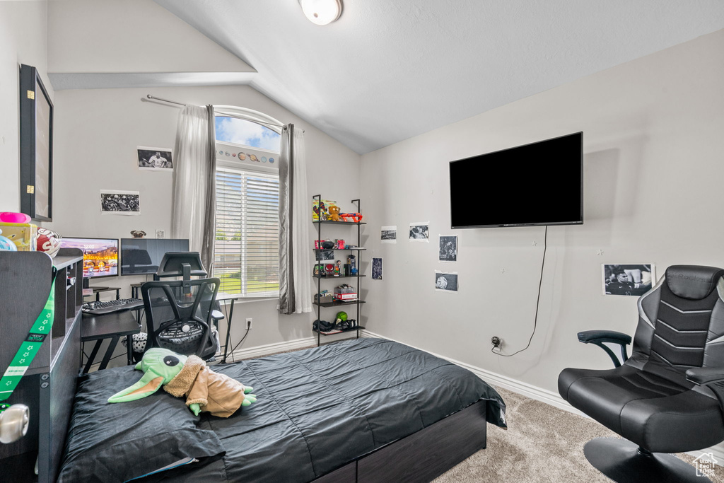 Bedroom with vaulted ceiling, carpet, and baseboards