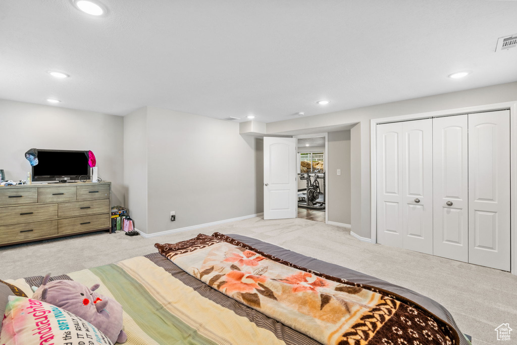 Bedroom featuring light carpet, recessed lighting, baseboards, and a closet
