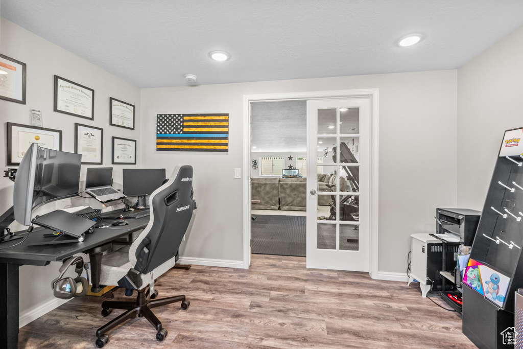 Office space featuring baseboards, french doors, and wood finished floors