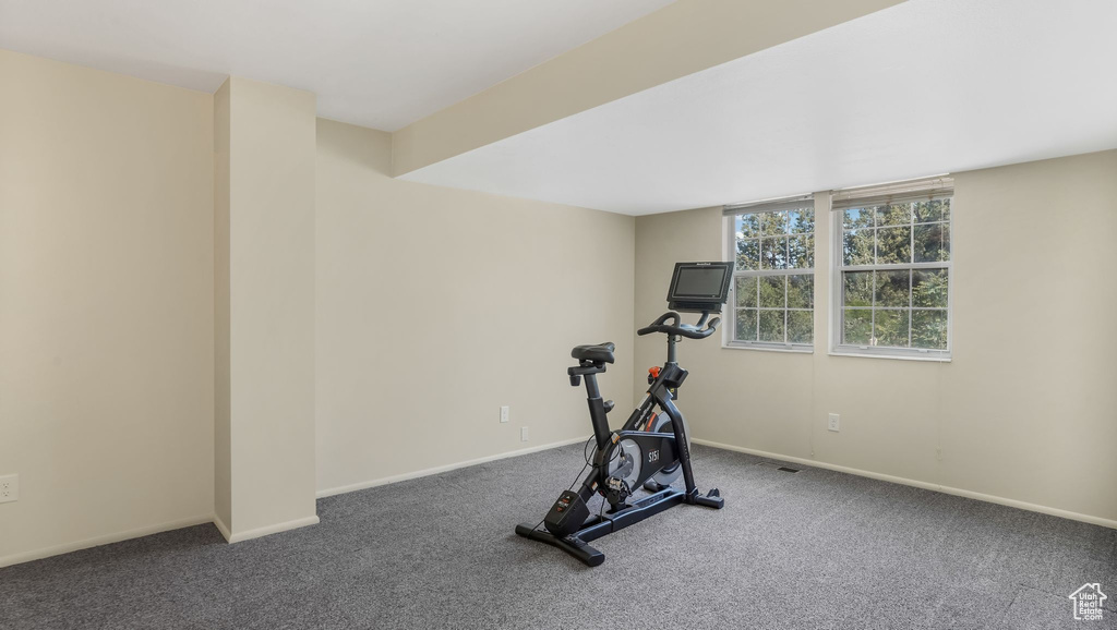 Exercise room with carpet floors and baseboards