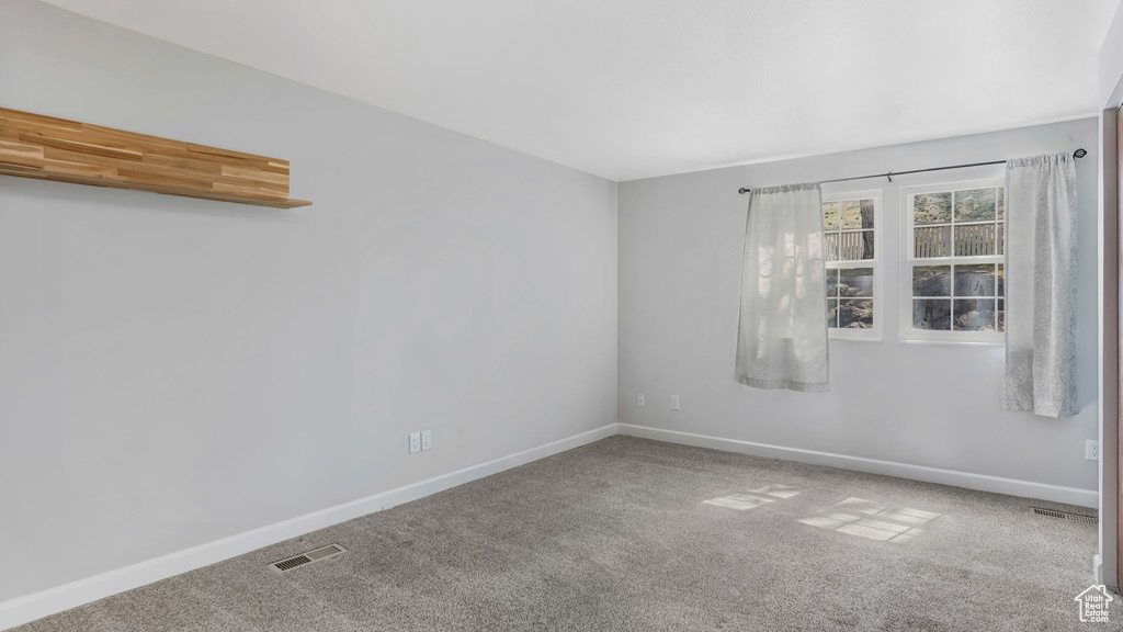 Carpeted empty room with baseboards