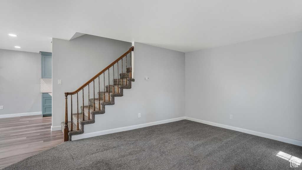 Staircase with baseboards and recessed lighting