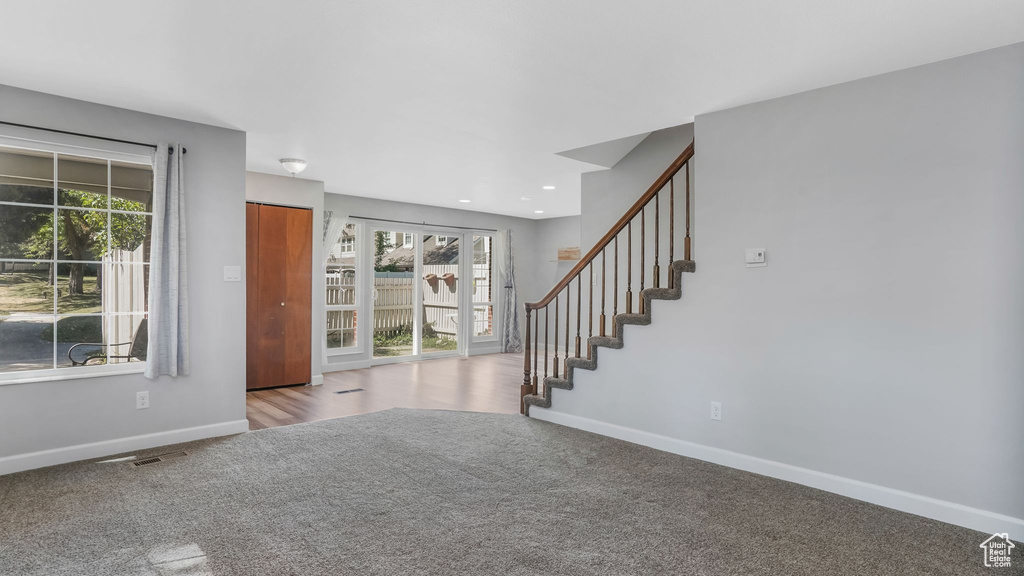 Foyer featuring carpet, baseboards, stairs, and recessed lighting