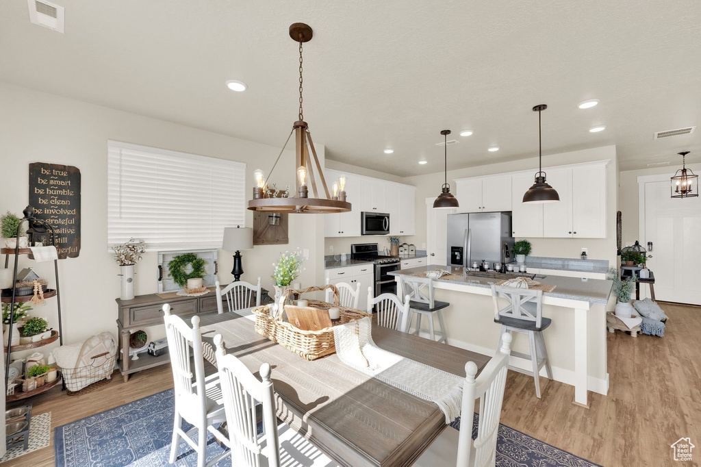 Dining area featuring light wood finished floors and recessed lighting