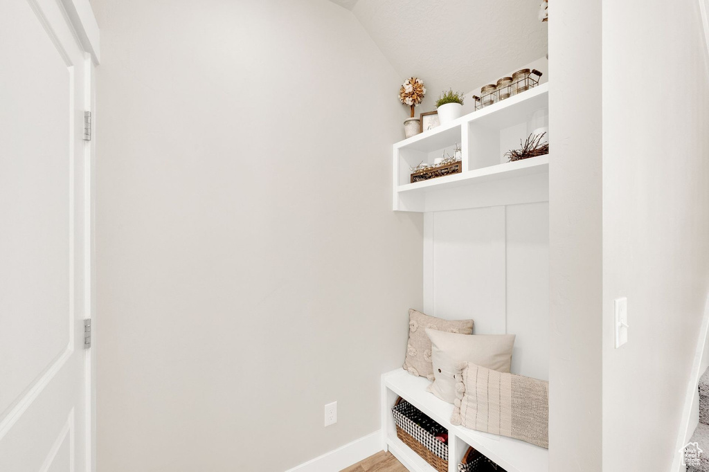 Mudroom with baseboards and lofted ceiling